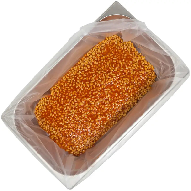 Sesame-coated food block in a tray liner for Gastronorm trays and pots