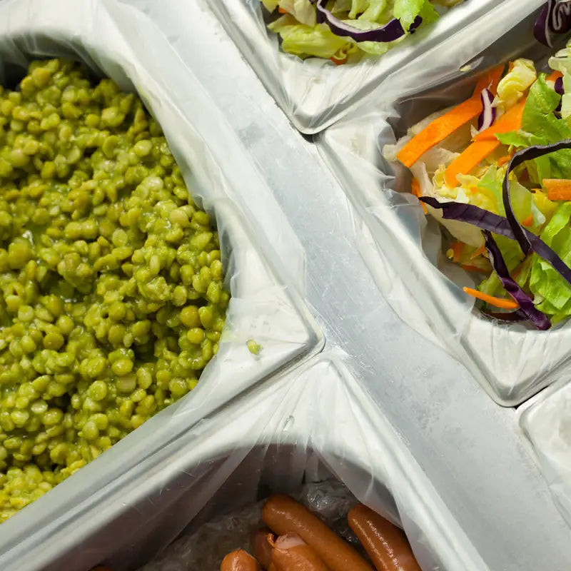 Green peas in a divided gastronorm tray with tray liner for easy serving