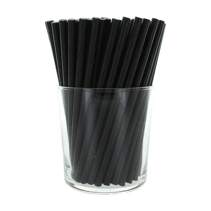 Black paper cocktail straws in a clear glass container for stylish serving