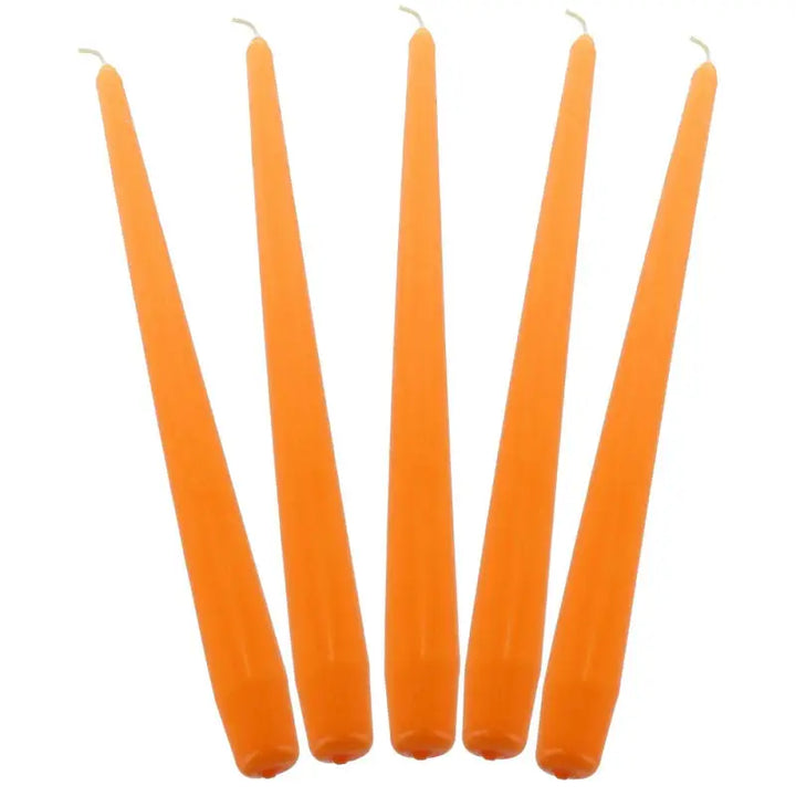 Five orange taper candles in a row for elegant dinner decor and ambiance