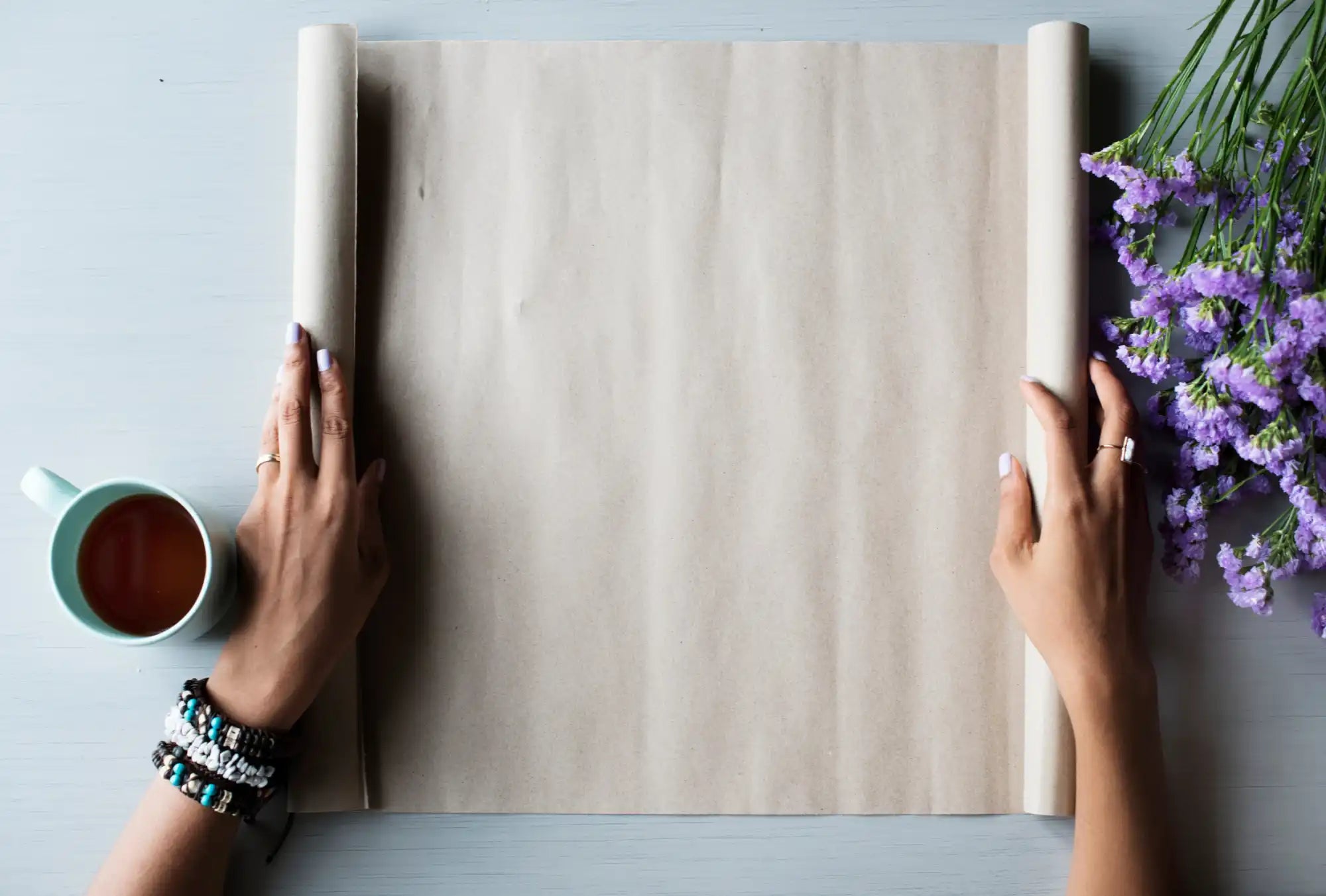 Blank paper scroll held open by two hands.