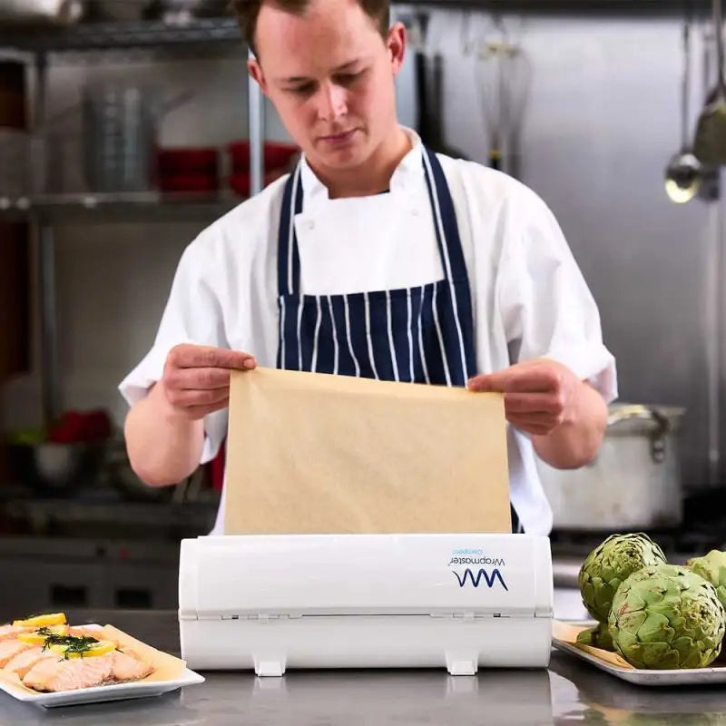 Chef using a vacuum sealer with Wrapmaster Compact Baking Parchment 30cm x 35m rolls