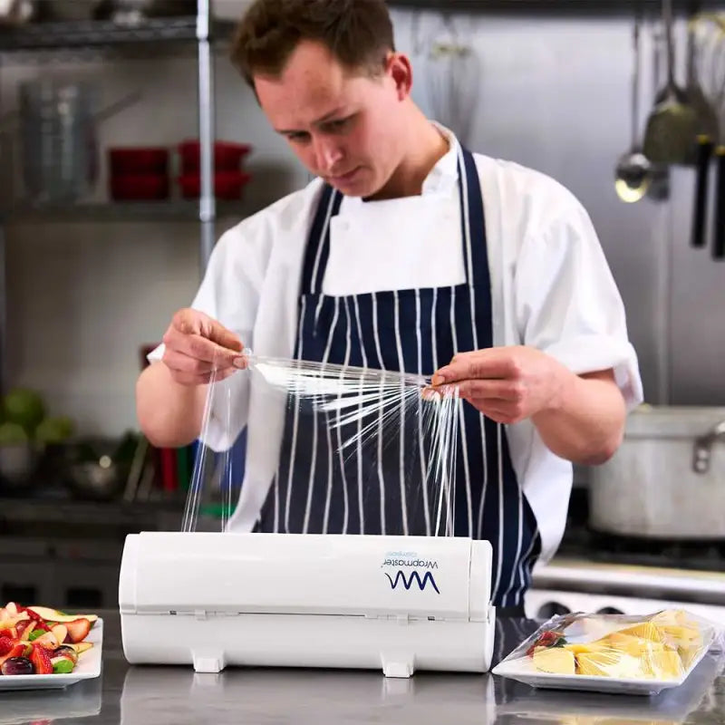 Chef using a vacuum sealer with Wrapmaster Compact Cling Film 30cm x 225m in kitchen