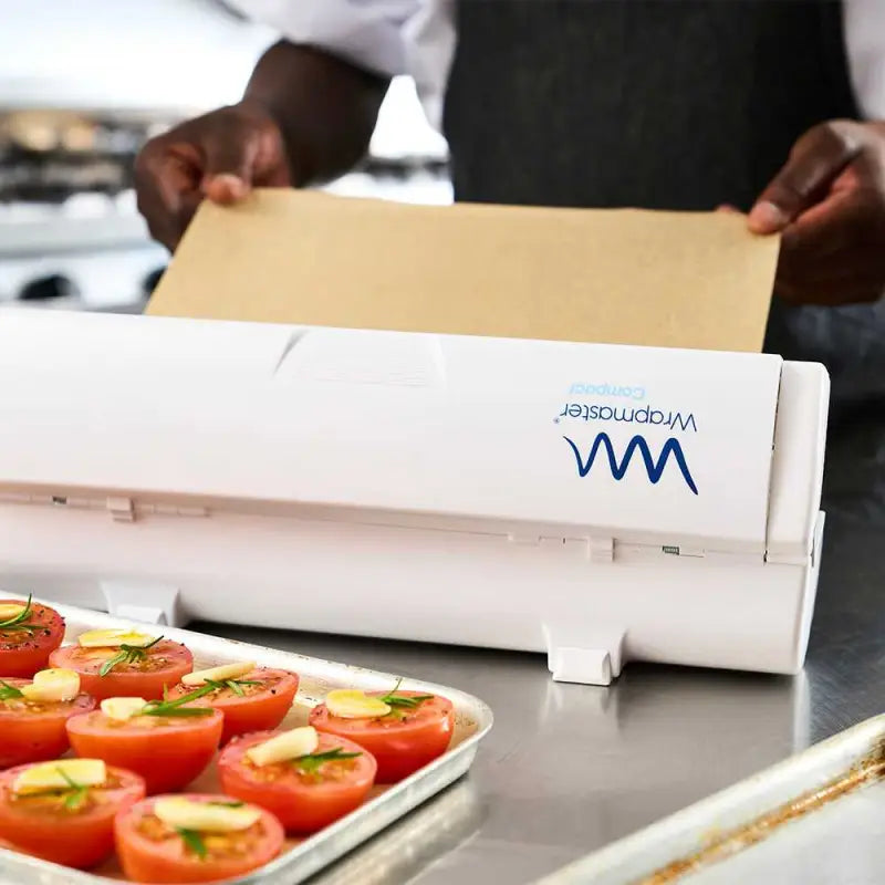 Food vacuum sealer machine with VacMaster branding beside Wrapmaster Compact Dispenser 63M15